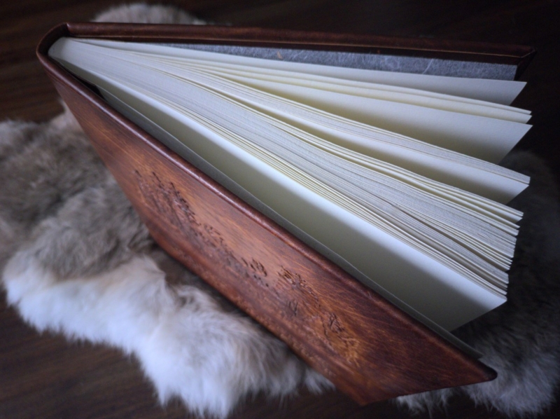 Book is placed onto furry rabbit skin. Photo presents the binding as seen from the top side.