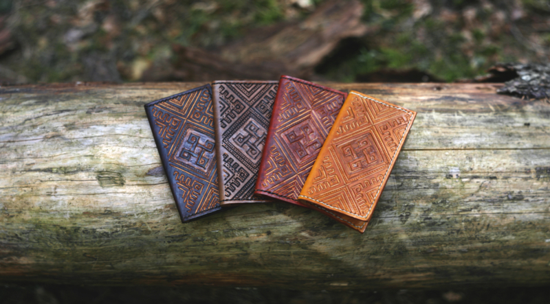 Leather card cases on the old fallen tree trunk.