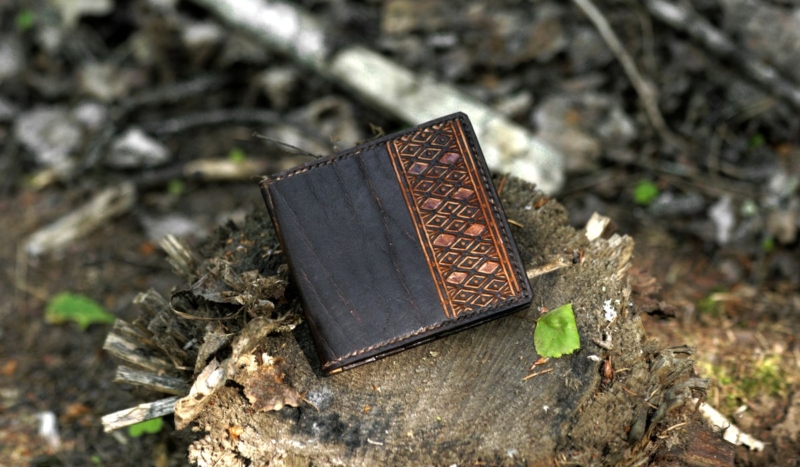 Dark brown carved leather card case with eight pockets.