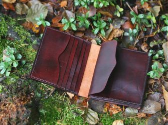 Leather file folder photographed on the mossy forest floor.