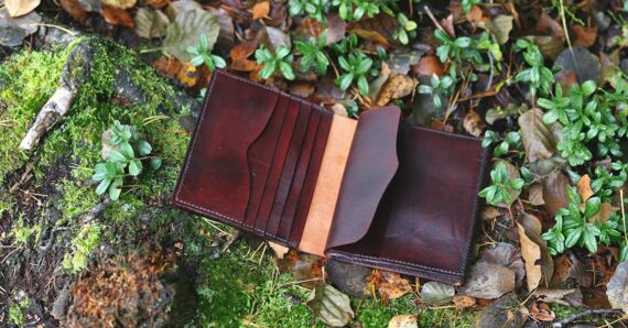 Leather file folder photographed on the mossy forest floor.