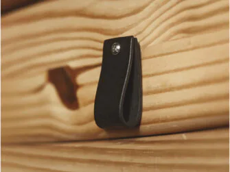 Leather loop handle attached to the wooden drawer.