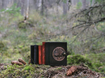 Leather wallets on mossy forest floor.