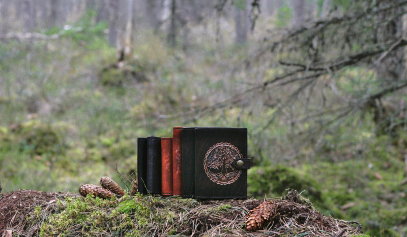 Leather wallets on mossy forest floor.