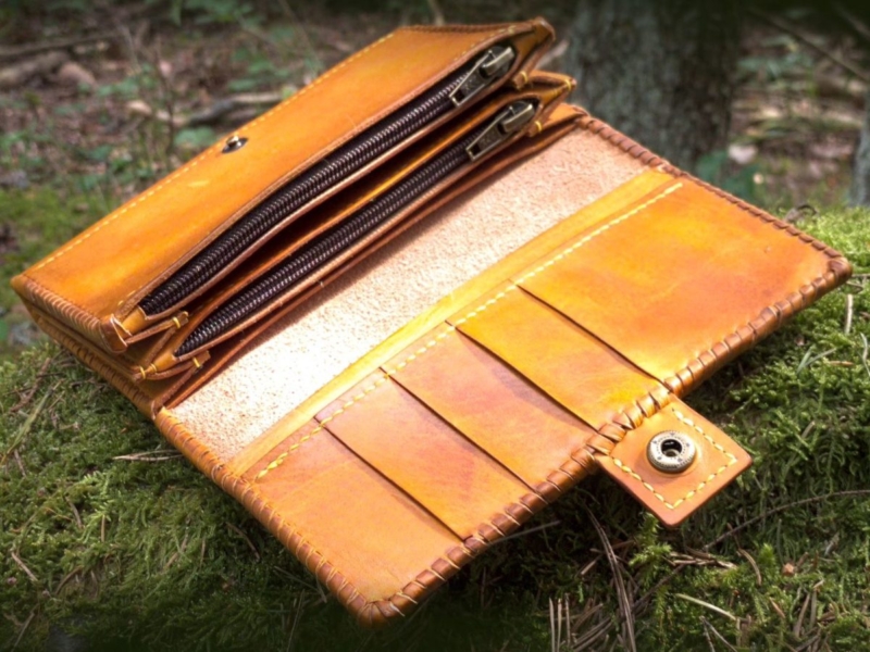 Opened wallet on green mossy forest ground.